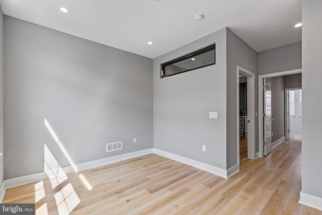 spare room featuring light wood-style flooring, recessed lighting, visible vents, and baseboards