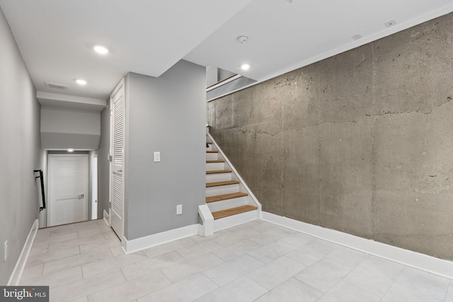 below grade area featuring recessed lighting, visible vents, stairway, and baseboards