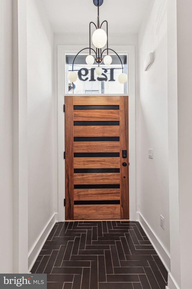 doorway featuring baseboards, brick floor, and a healthy amount of sunlight