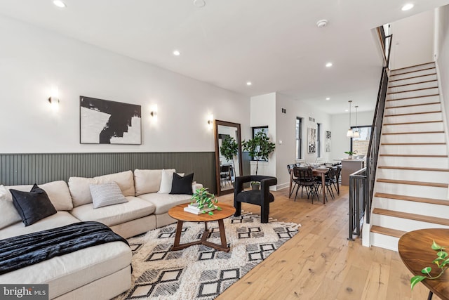 living area featuring stairs, a wainscoted wall, light wood-type flooring, and recessed lighting