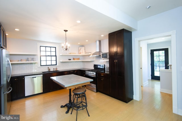 kitchen with decorative backsplash, sink, wall chimney range hood, and stainless steel appliances