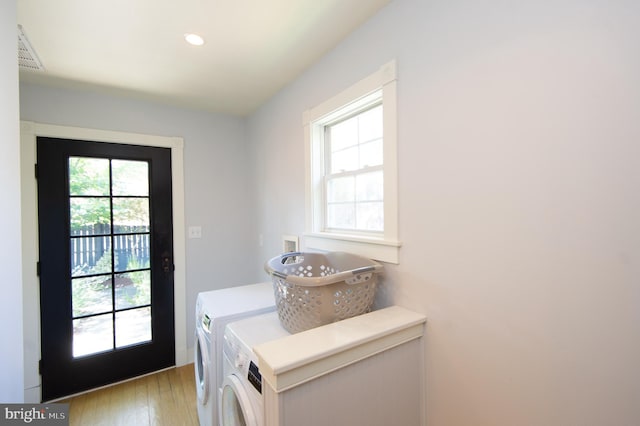 laundry area with washer and clothes dryer and light hardwood / wood-style flooring