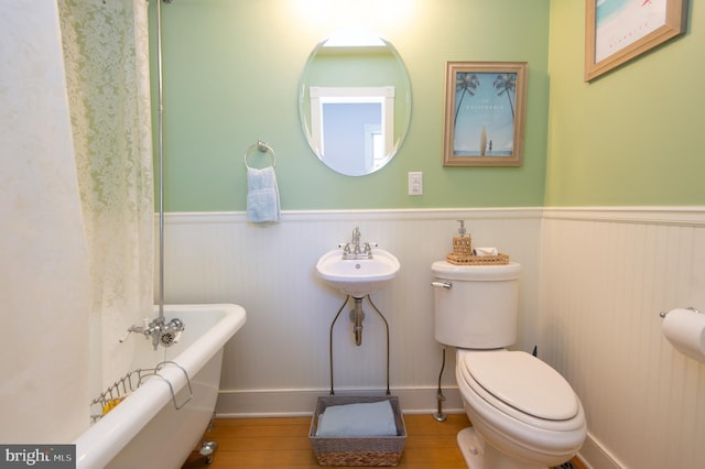 bathroom featuring sink, a bath, and toilet