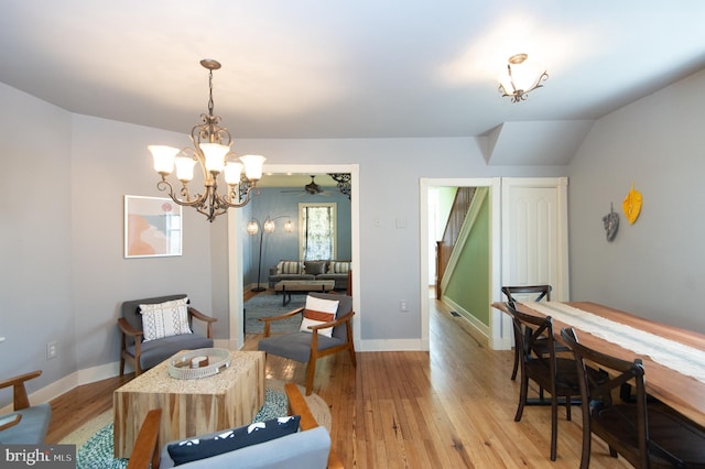 dining area featuring ceiling fan with notable chandelier and light hardwood / wood-style flooring