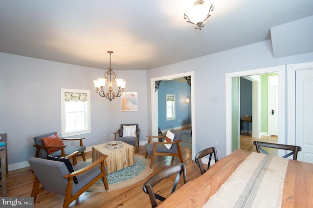 dining room with light wood-type flooring and a notable chandelier