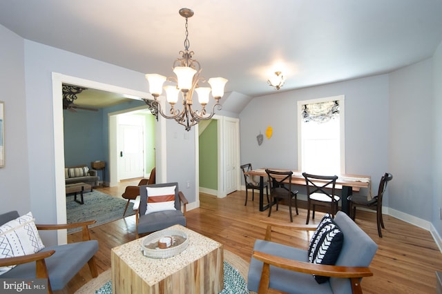 living room with hardwood / wood-style floors and ceiling fan with notable chandelier