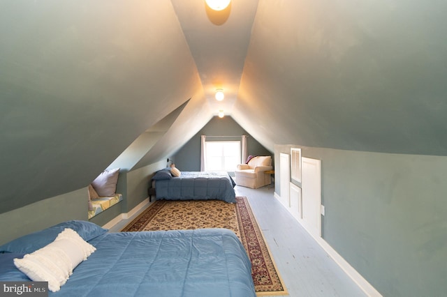 bedroom with wood-type flooring and lofted ceiling