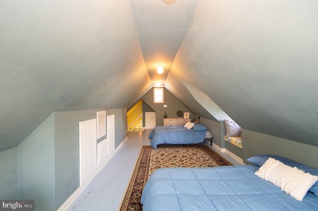 bedroom featuring light hardwood / wood-style flooring and lofted ceiling