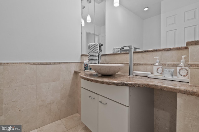 bathroom featuring tile patterned flooring, vanity, and tile walls