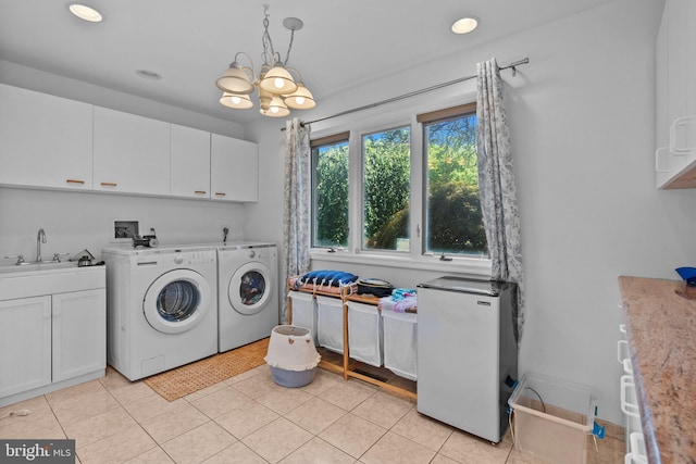 clothes washing area with cabinets, sink, light tile patterned floors, separate washer and dryer, and a chandelier