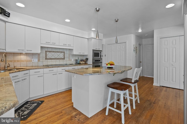 kitchen with white cabinets, sink, light wood-type flooring, and stainless steel appliances