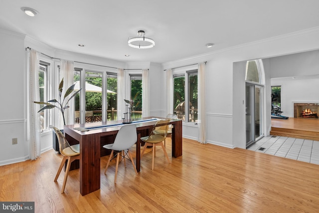 dining space featuring light wood-type flooring and ornamental molding