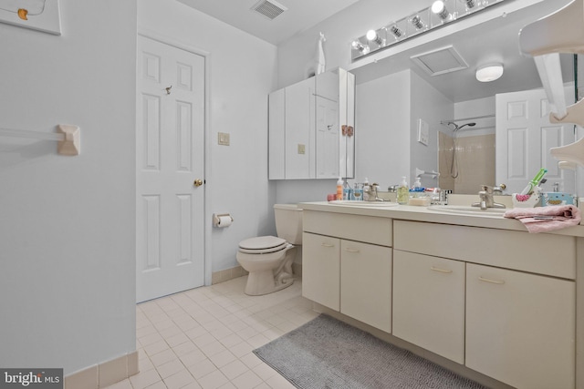 bathroom with tiled shower, vanity, tile patterned flooring, and toilet