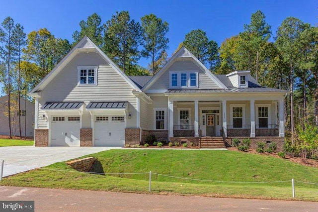 view of front of house with covered porch, a front yard, and a garage