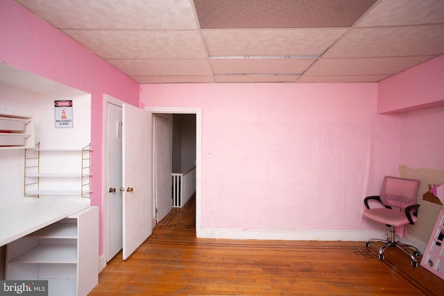 basement with a paneled ceiling and hardwood / wood-style floors