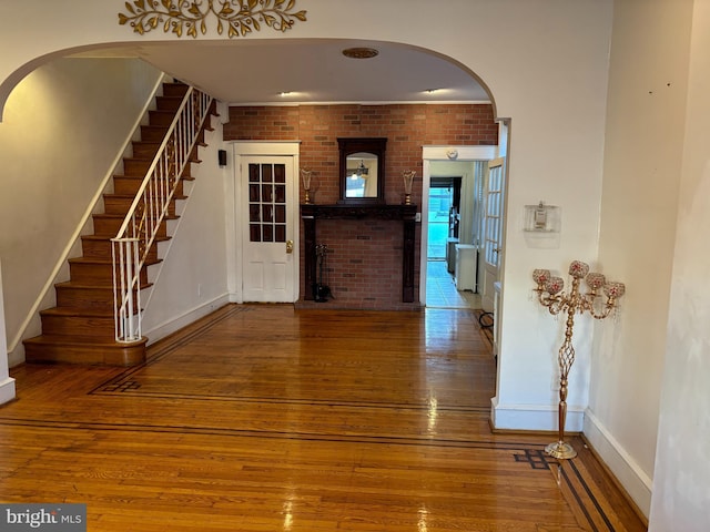 entrance foyer with wood-type flooring and brick wall