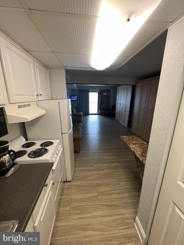 kitchen featuring white electric range oven, white cabinetry, extractor fan, and wood-type flooring