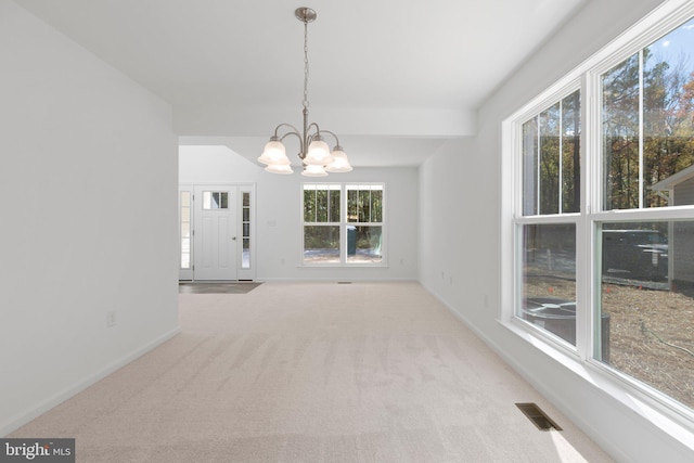 unfurnished dining area featuring light carpet and a chandelier