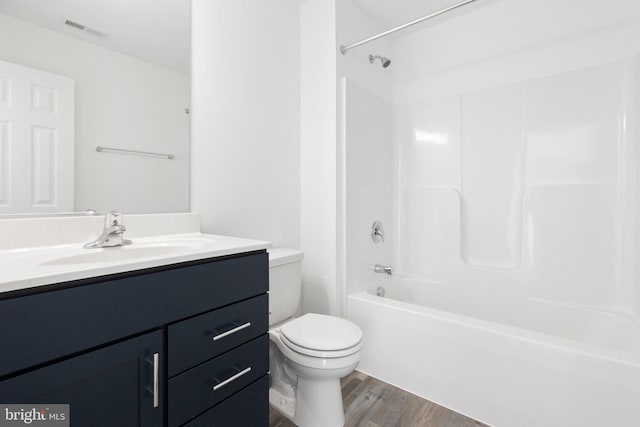 full bathroom with vanity, hardwood / wood-style flooring, toilet, and shower / washtub combination