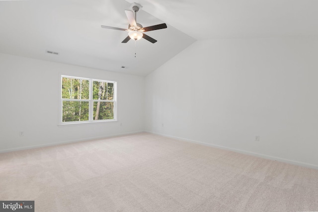 carpeted empty room with ceiling fan and vaulted ceiling