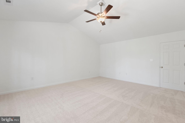 spare room with ceiling fan, light carpet, and vaulted ceiling