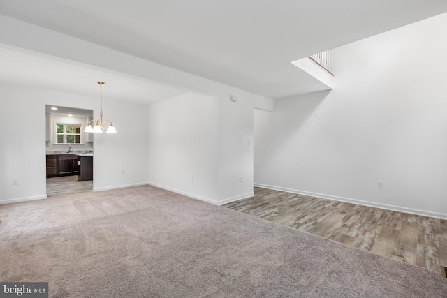 unfurnished living room featuring light hardwood / wood-style flooring and a chandelier