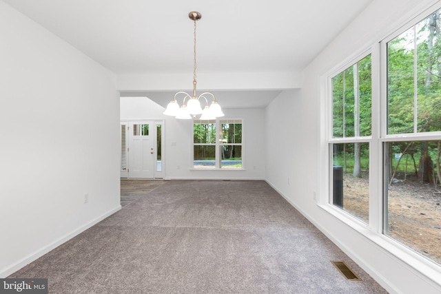 interior space with carpet flooring, a healthy amount of sunlight, and a chandelier