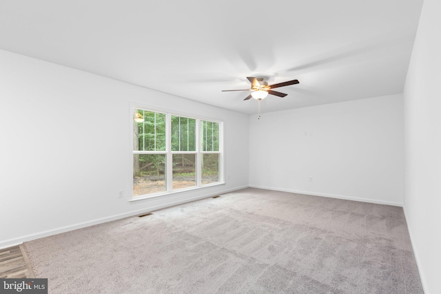 carpeted spare room with ceiling fan