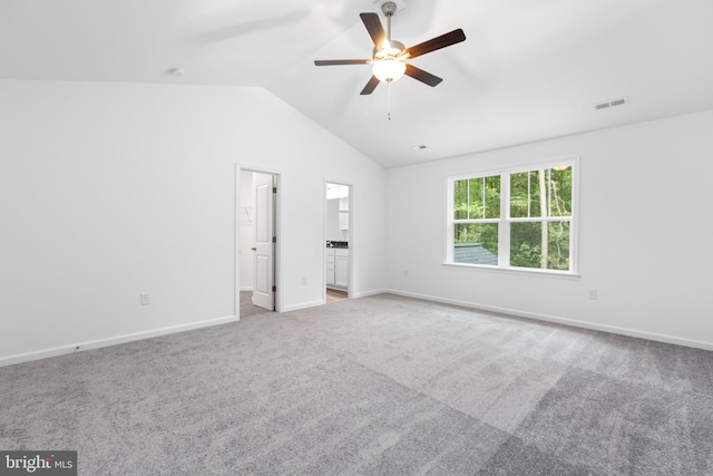 unfurnished bedroom featuring carpet floors, vaulted ceiling, ceiling fan, and connected bathroom