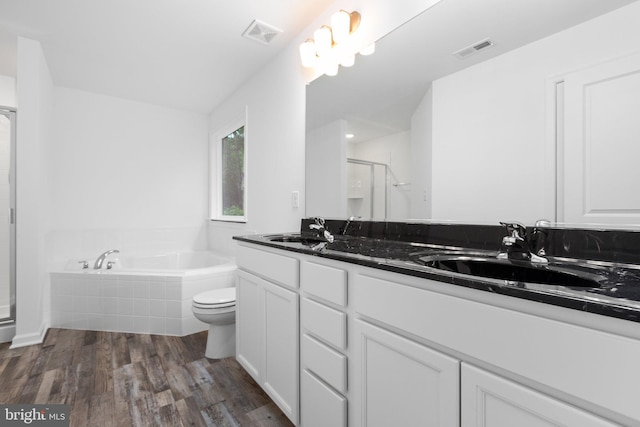 full bathroom with plus walk in shower, hardwood / wood-style floors, vanity, and toilet