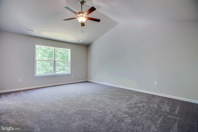 empty room with carpet floors, vaulted ceiling, and ceiling fan