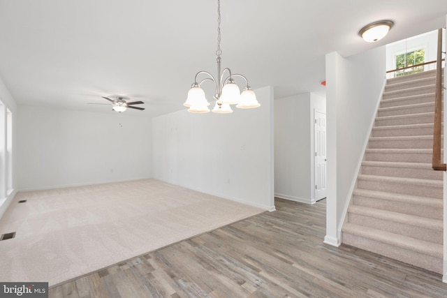 interior space featuring hardwood / wood-style floors and ceiling fan with notable chandelier