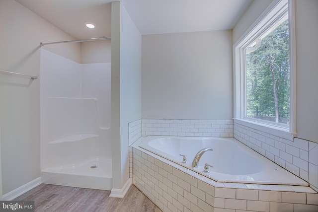 bathroom with hardwood / wood-style floors, a healthy amount of sunlight, and independent shower and bath