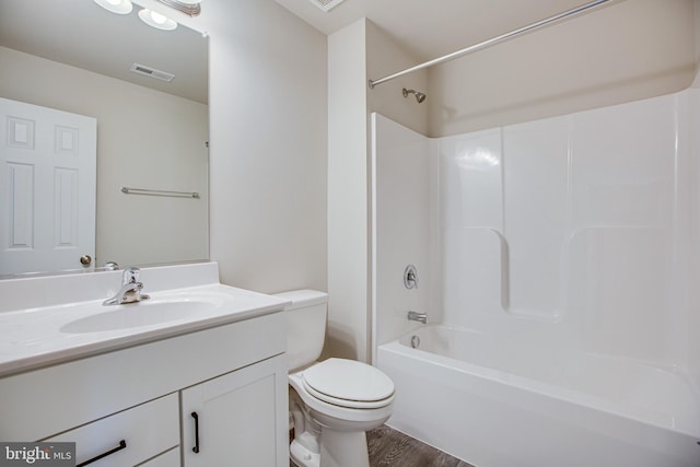 full bathroom with bathtub / shower combination, hardwood / wood-style floors, vanity, and toilet