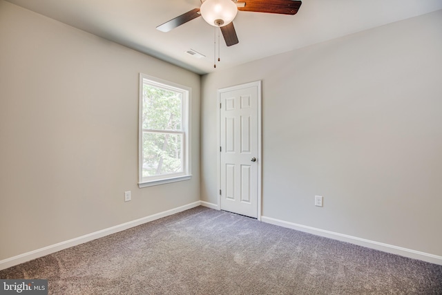 carpeted spare room featuring ceiling fan