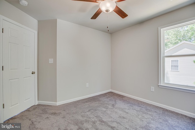 carpeted spare room with ceiling fan