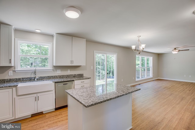 kitchen with light wood-type flooring, a kitchen island, sink, dishwasher, and white cabinetry