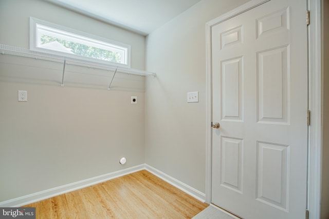 clothes washing area with electric dryer hookup and hardwood / wood-style flooring