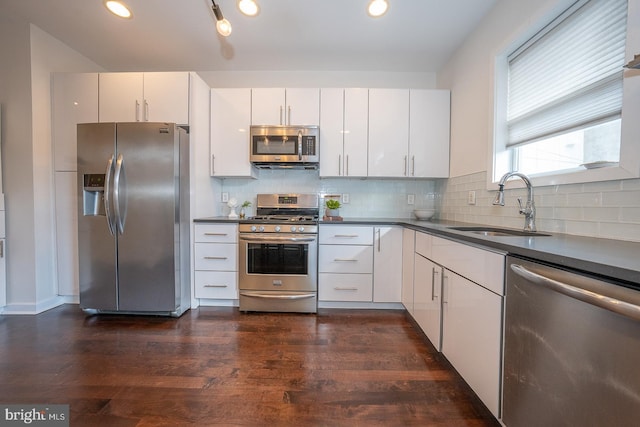 kitchen featuring white cabinets, sink, appliances with stainless steel finishes, and dark wood-type flooring