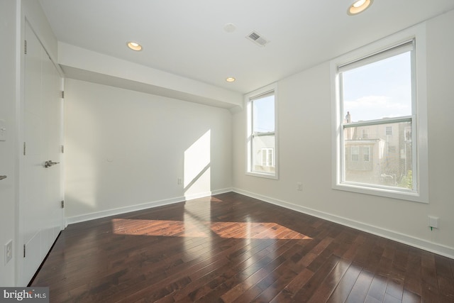 unfurnished room with dark hardwood / wood-style floors and plenty of natural light