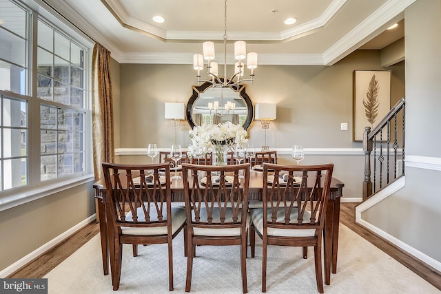 dining area with a notable chandelier, a healthy amount of sunlight, and wood-type flooring