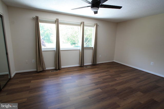 empty room with dark hardwood / wood-style flooring and ceiling fan