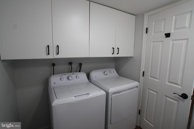 laundry room featuring washer and dryer and cabinets