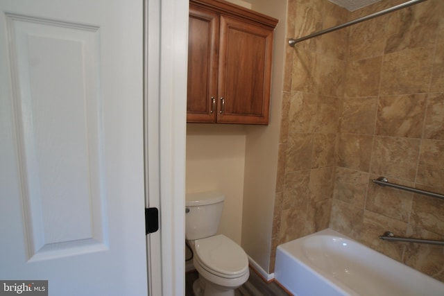 bathroom with tiled shower / bath combo and toilet