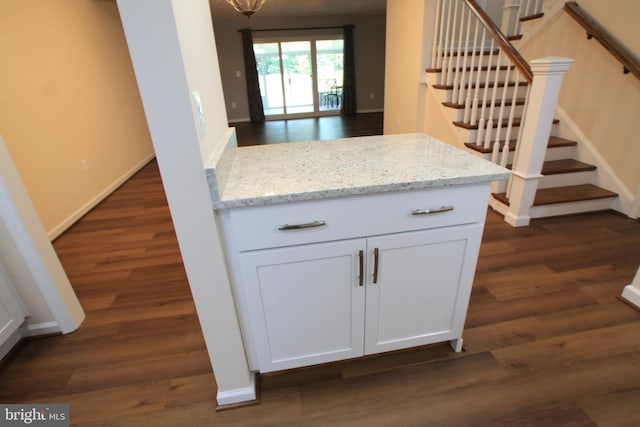 kitchen featuring light stone countertops, white cabinets, and dark hardwood / wood-style floors