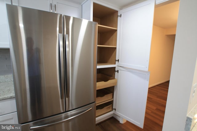 kitchen featuring white cabinetry, stainless steel fridge, and dark hardwood / wood-style floors