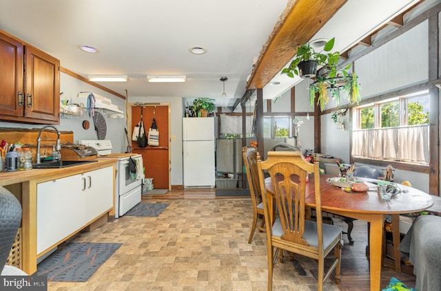 kitchen with butcher block countertops, sink, pendant lighting, and white appliances