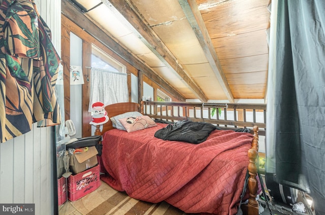 bedroom featuring multiple windows and wood walls