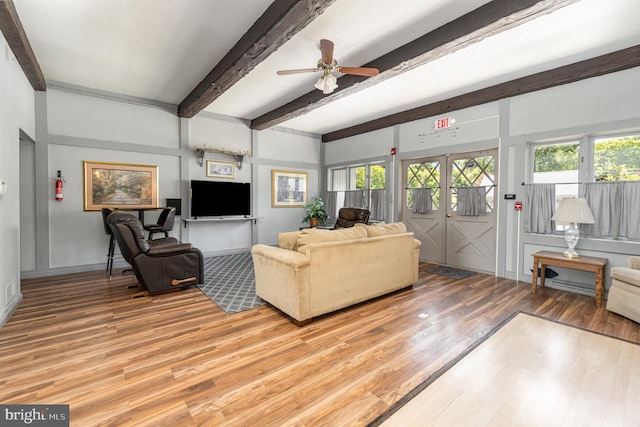 living room featuring ceiling fan, beam ceiling, and light wood-type flooring