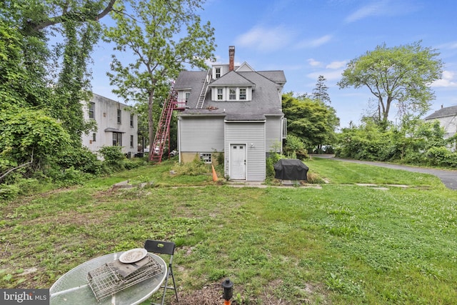 rear view of house featuring a lawn